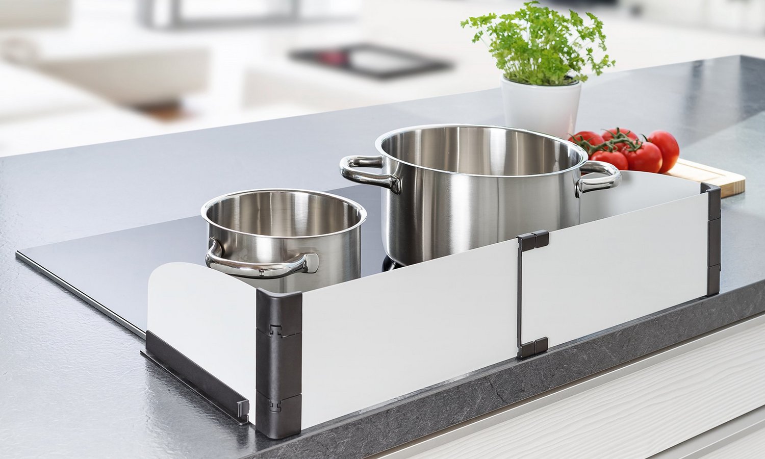 Ein Herd mit Töpfen ist durch ein Herdschutzgitter gesichert