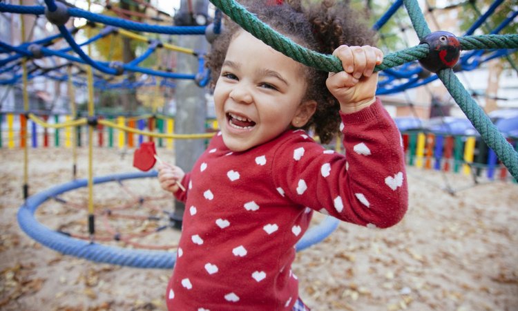 Ein Mädchen spielt auf einem Klettergerüst