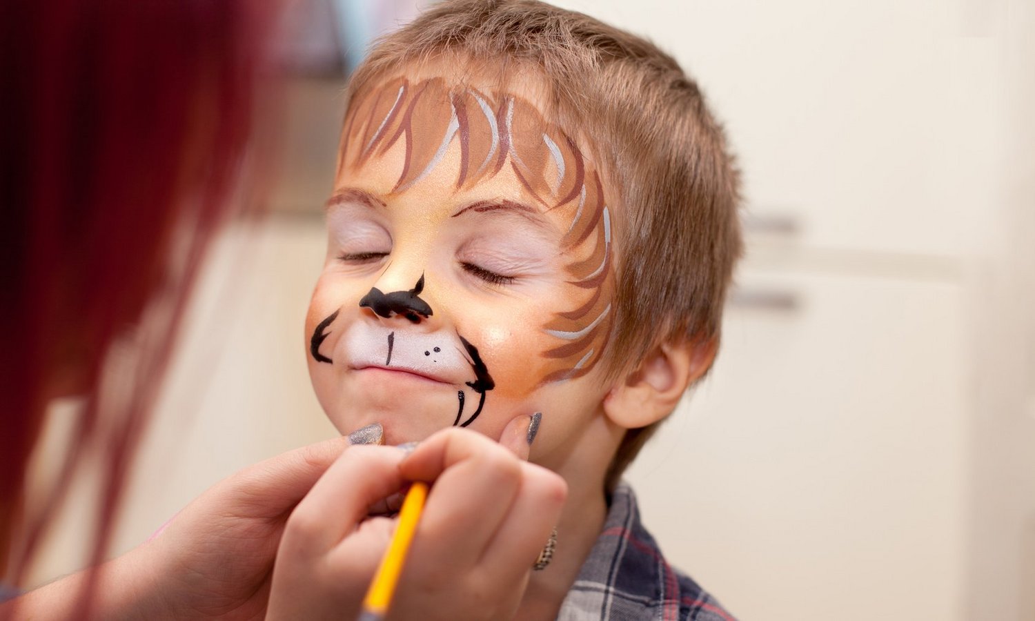 Ein Kind wird im Gesicht geschminkt