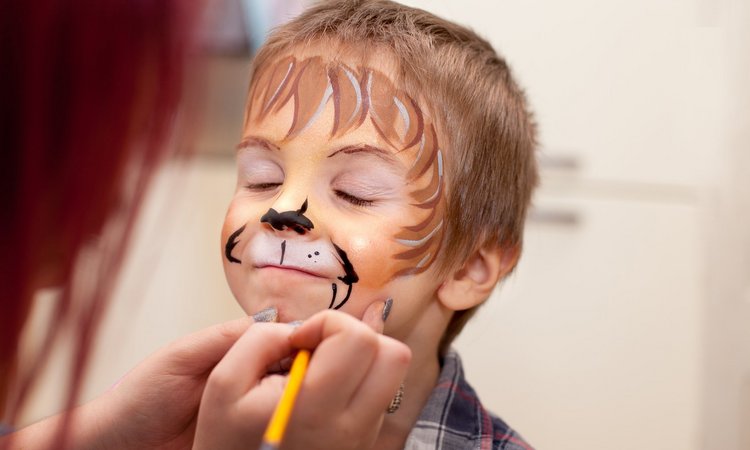 Ein Kind wird im Gesicht geschminkt