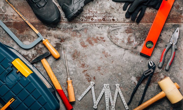 Verschiedene Werkzeuge liegen auf einem angelaufenen Metalltisch