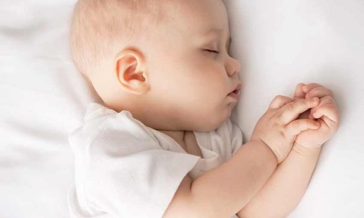 Ein Baby liegt schlafend auf der Seite