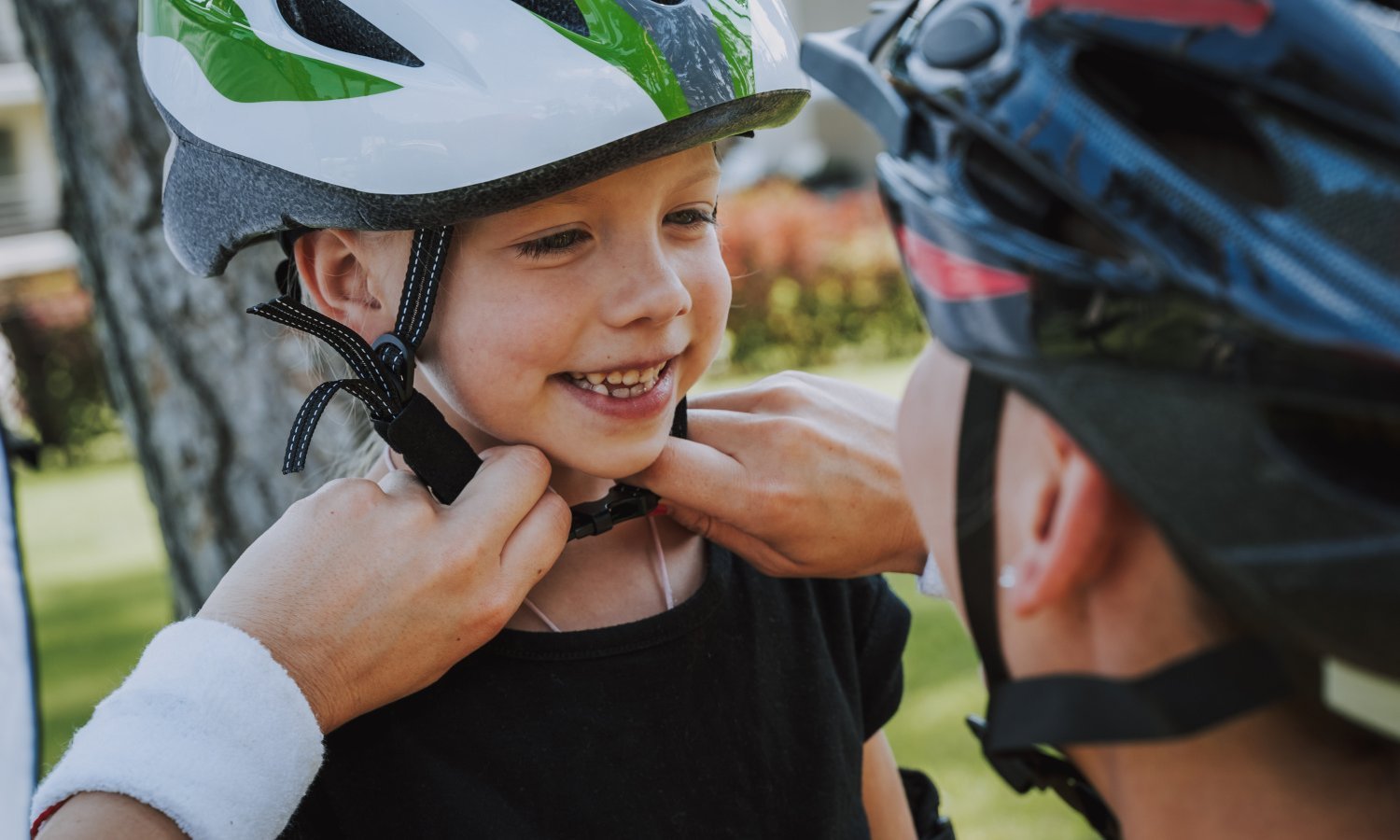 Eine Frau zieht einem Jungen einen Fahrradhelm an