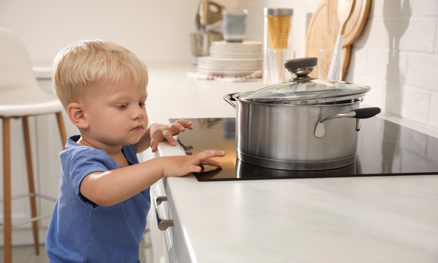 Junge fasst auf die Herdplatte