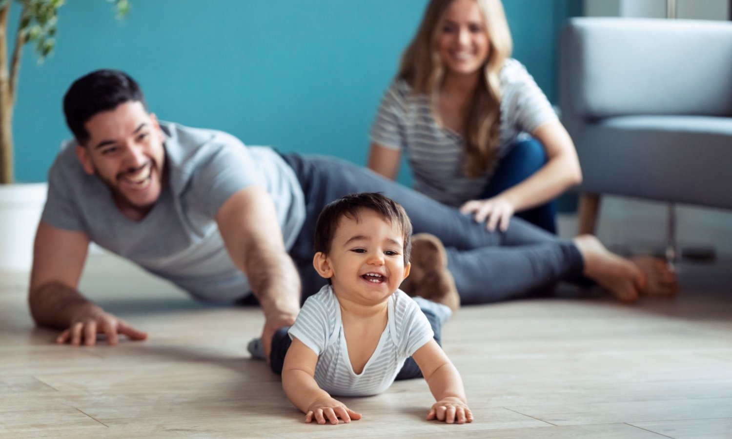 Mann und Frau spielen mit Baby auf dem Fußboden