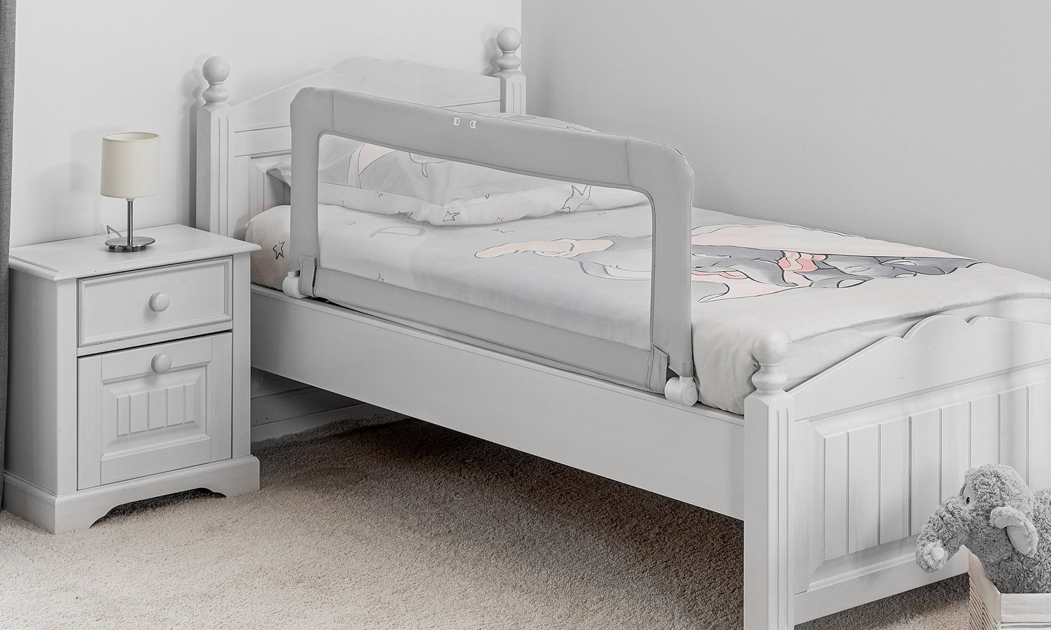 Ein graues Kinderbett mit Bettgitter