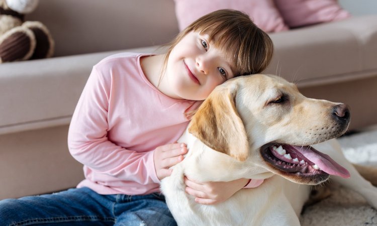 Ein Mädchen kuschelt glücklich mit einem Hund