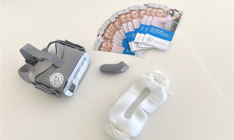 VR-Brille mit Flyern und Schutzmasken