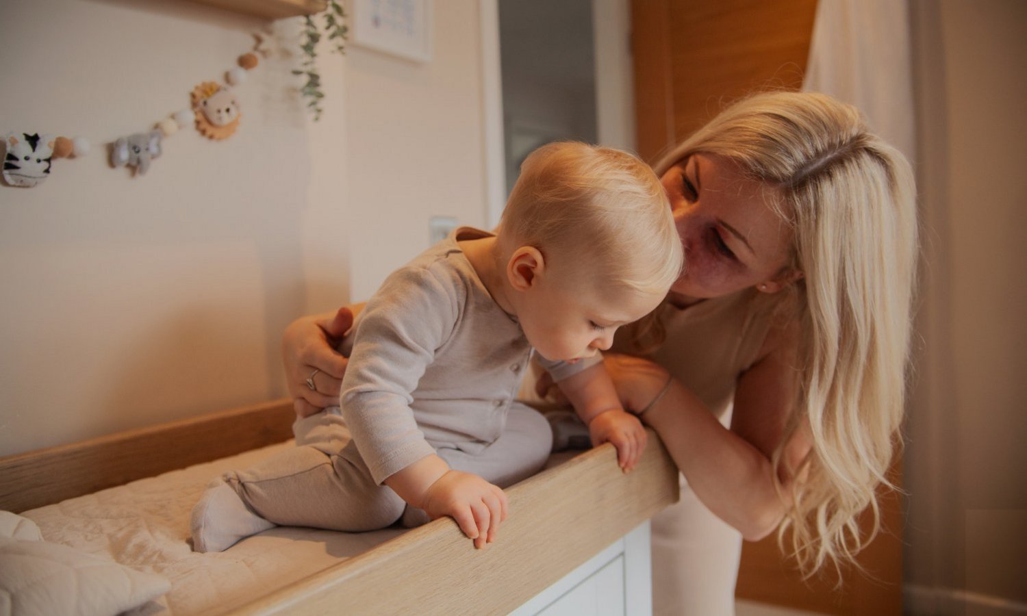 Eine Frau hält ein Baby auf dem Wickeltisch fest