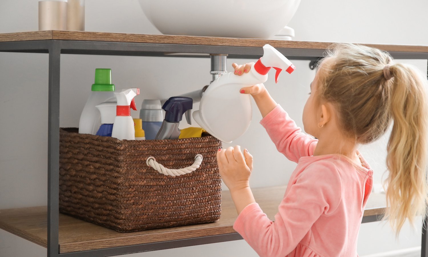 Kind greift nach Flasche mit Reinigungsmittel im Regal